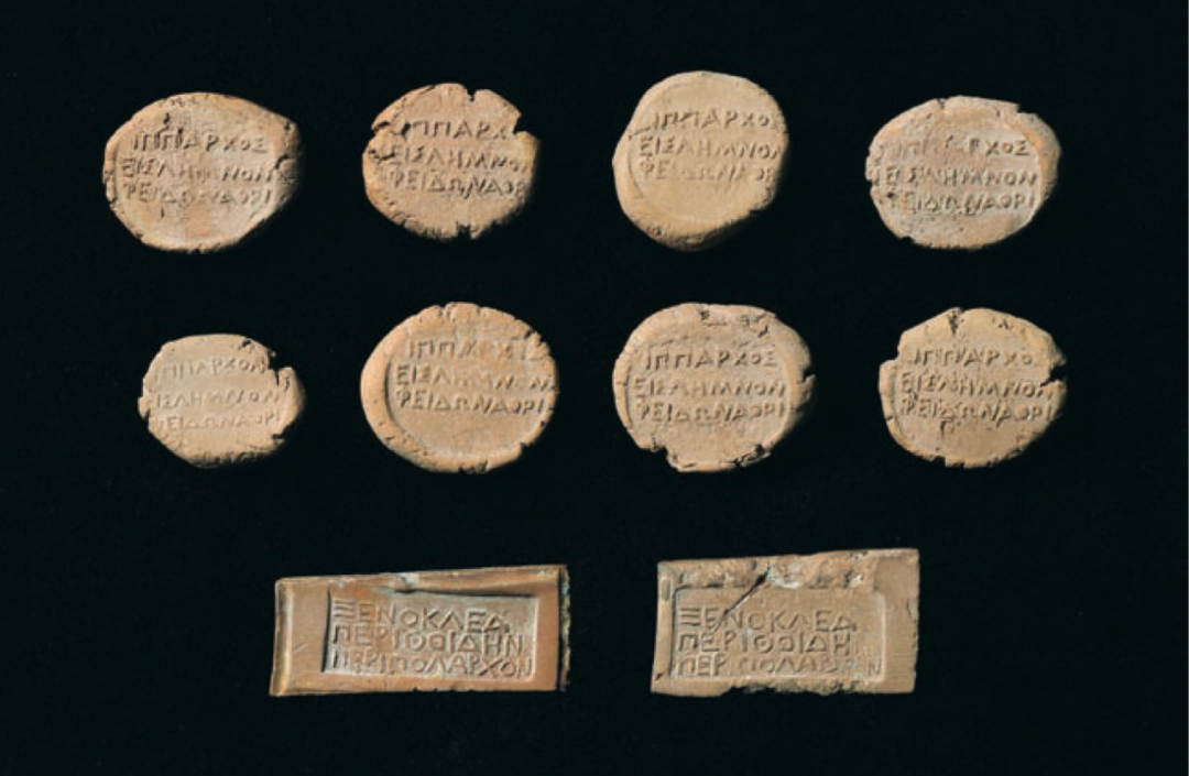 （上）希俄斯岛特里阿西亚德谟的斐伊冬所用圆形赤陶令牌，公元前四世纪，时任雅典驻利姆诺斯岛骑兵指挥官；（下）佩里托伊代德谟的克塞诺克勒斯所用长方形赤陶筹码，公元前四世纪.png
